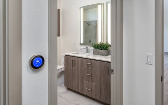 an open door leading to a bathroom with a mirror and a sink