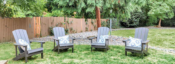 Four chairs are placed on a lawn.