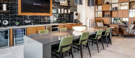 a kitchen with a long island with green chairs at Icon Apartment Homes at Ferguson Farm, Bozeman, Montana