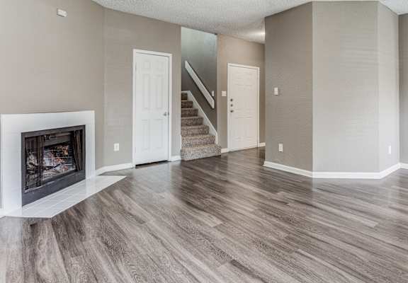 a living room with a fireplace and a ceiling fan