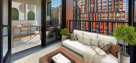 a living area with a couch and a desk in a balcony