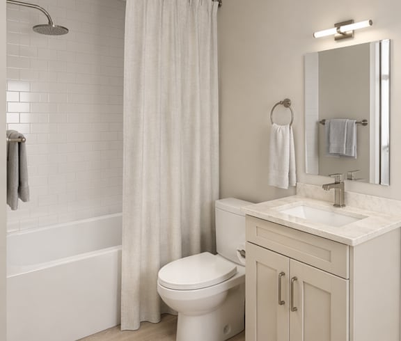 A white bathroom with a toilet, sink, and shower.
