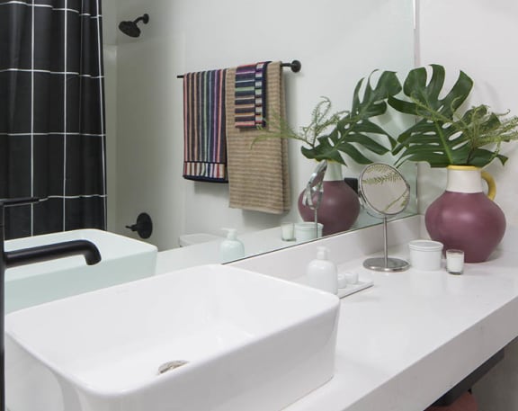 a white bathroom with a sink and a mirror at The Flat, Los Angeles, CA
