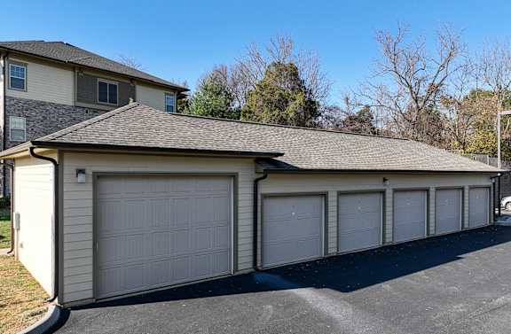 a 3 car garage with a house behind it