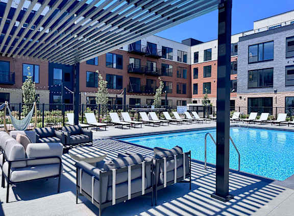 A pool area with sun loungers and a hammock.