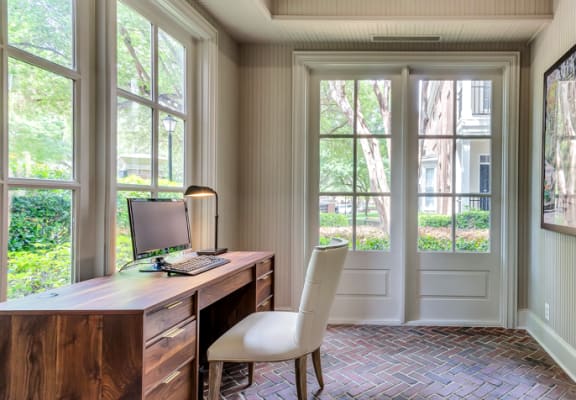 a home office with a brick wall and a desk with a computer