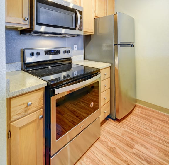a kitchen with stainless steel appliances and wooden cabinets
