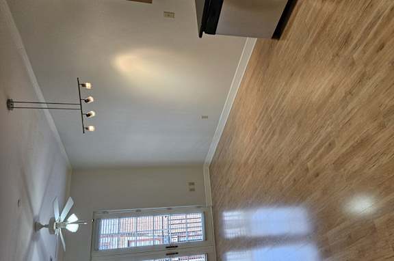A room with a ceiling fan and a window.