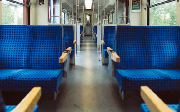 the inside of a train with blue benches