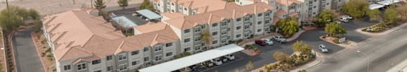 A parking lot with cars and a building with a pool in the foreground.