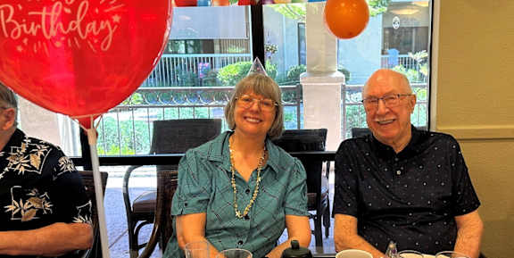 A birthday party with a red balloon and a "Happy Birthday" sign.