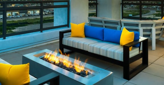 Rooftop patio with tables and chairs and firepit at dusk