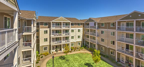 Apartment complex with a green lawn in the middle.