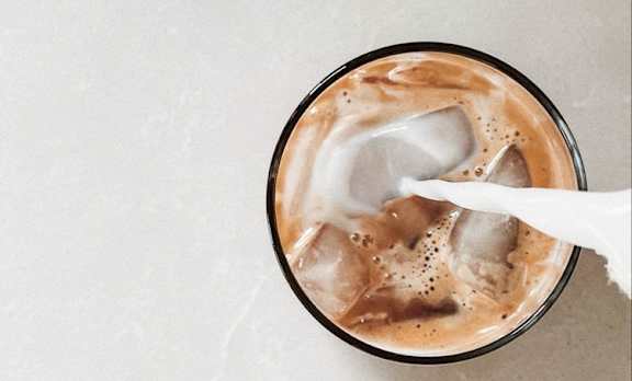 A glass of iced coffee with a white napkin on the side.
