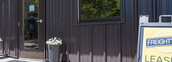A Freightyard Leasing Office sign is on the sidewalk in front of a building.