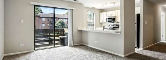 A spacious, empty room with a view of a building outside the window.