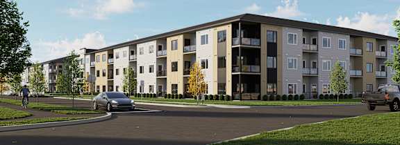 A modern apartment complex with cars parked in front.