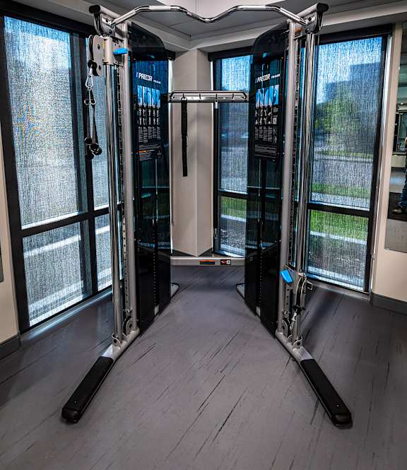 a fitness room with cardio machines and a window