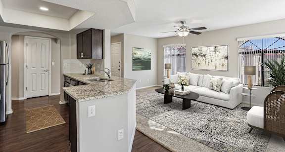 A modern kitchen with a white island and a white sofa in the living room. at San Montego Apartments, Mesa, AZ, 85206