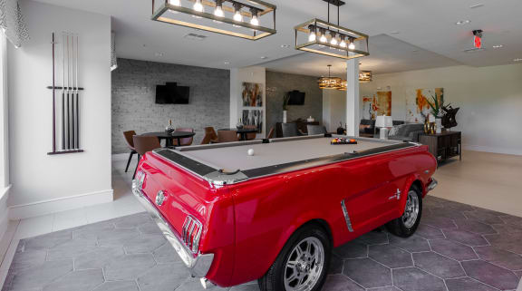 a red pool table with a black top in a room with white walls