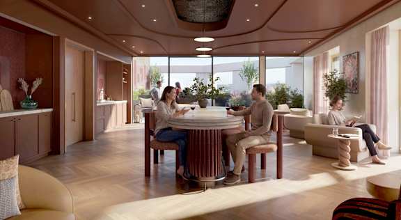 A group of people are sitting around a table in a modern, well-lit room.