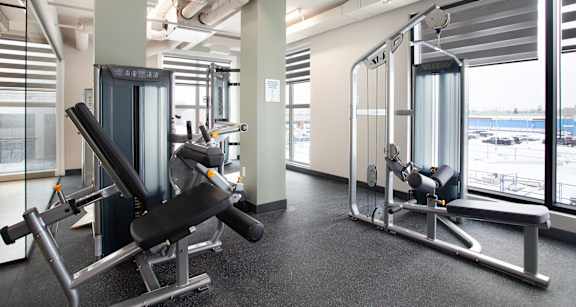 A gym with a row of exercise machines.