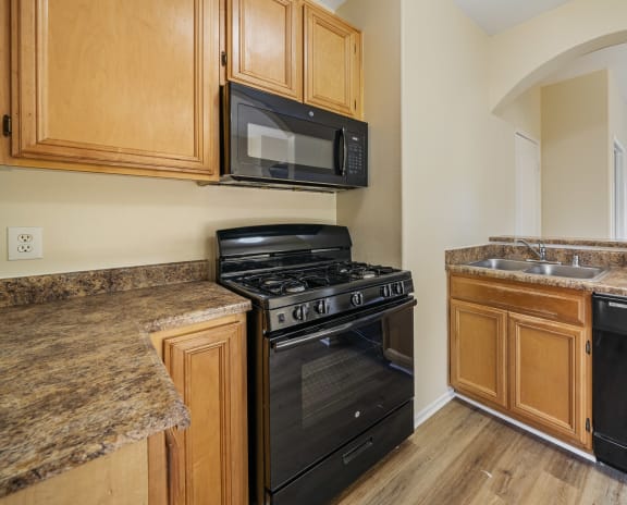 a kitchen with wood cabinets and black appliances