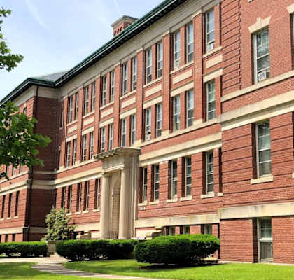 a large brick building with grass in front of it