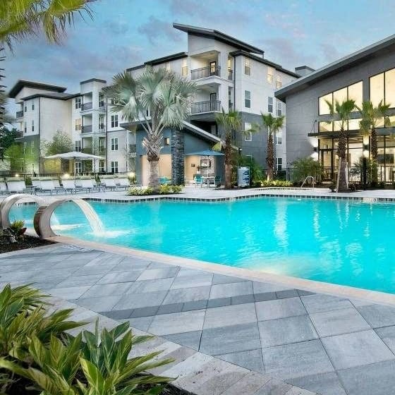 a large swimming pool with buildings in the background