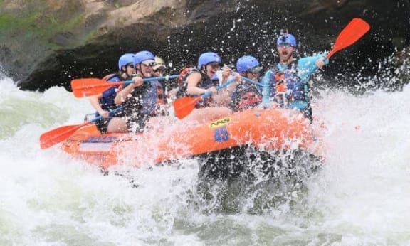 a group of people riding a kayak in a river