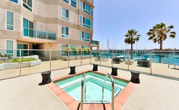 A pool area with a building in the background. at Esprit Apartments, Marina del Rey