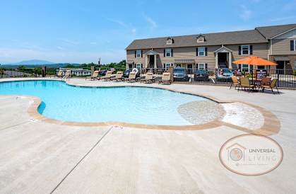 our resort style swimming pool is surrounded by chairs and a building