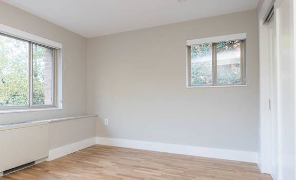 Bedroom with custom closets and large picture windows