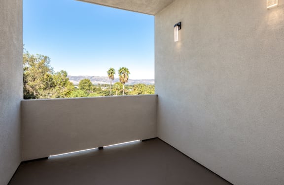 a room with a large window and a view of palm trees