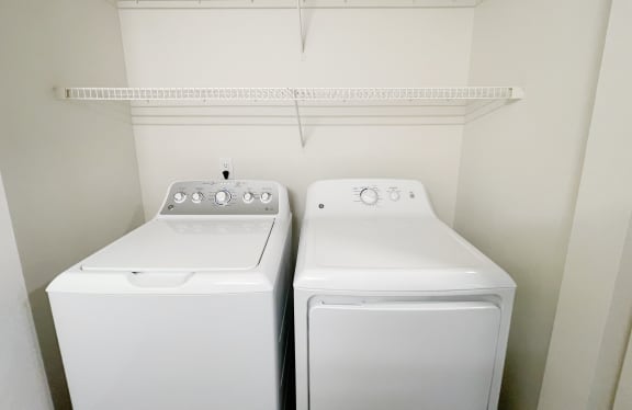 an empty laundry room with two washes and a dryer  at The Trail, Snohomish, Washington