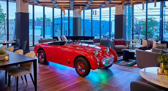 a room with a red convertible car in the middle of it at Dey & Bergen, Harrison, 07029