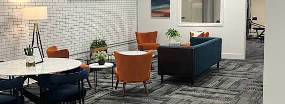 A room with a white table and chairs with a grey carpet.