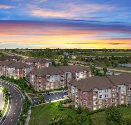 Aerial view of property at sunset at The Residences at Bluhawk Apartments, Overland Park, 66085