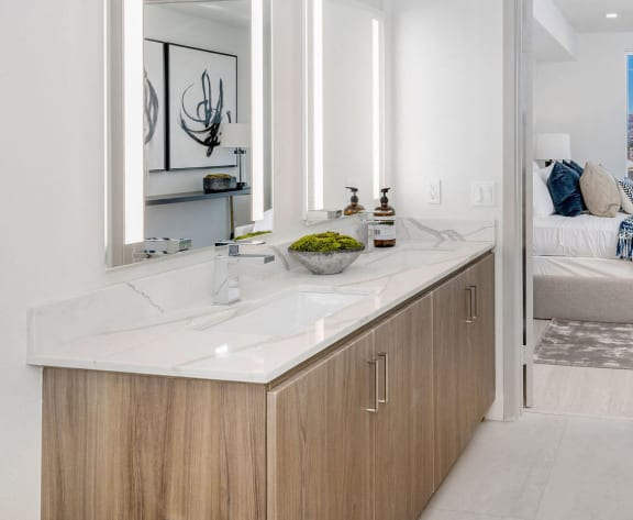 a bathroom with a shower and a sink and a bedroom