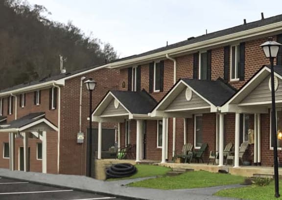 a parking lot in front of a row of brick apartment buildings