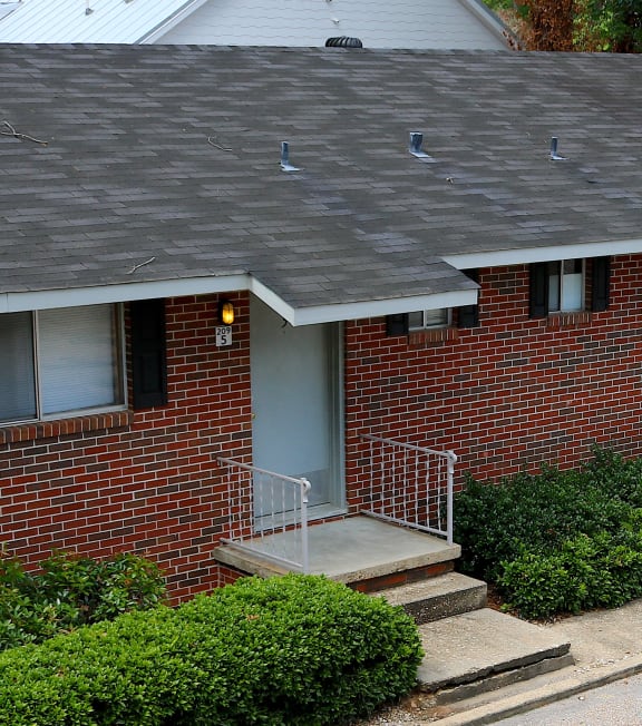 an aerial view of a brick house with a motor scooter parked in the driveway