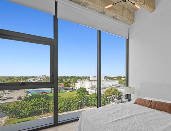 A bedroom with a large bed and a view of the city.