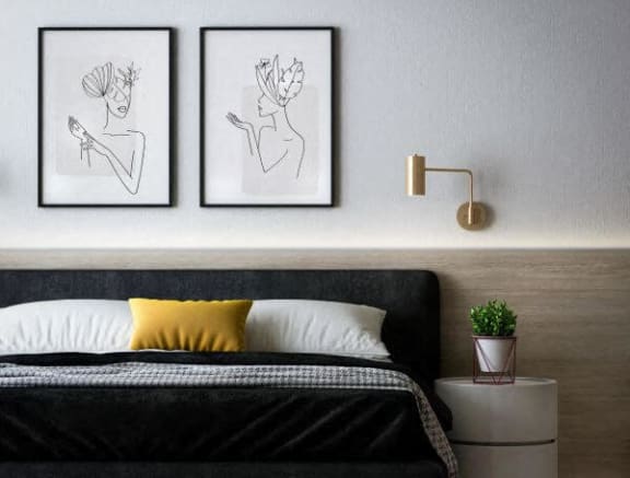 a bedroom with a bed and two pictures on the wall