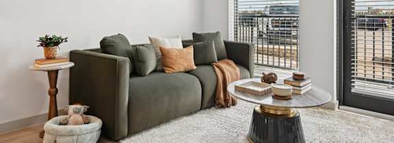 a living room with a couch and a table with a vase of flowers on it