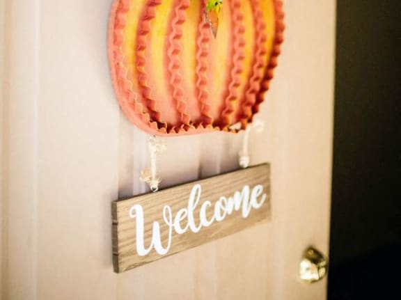 a pink pumpkin door decoration with a welcome sign on the door
