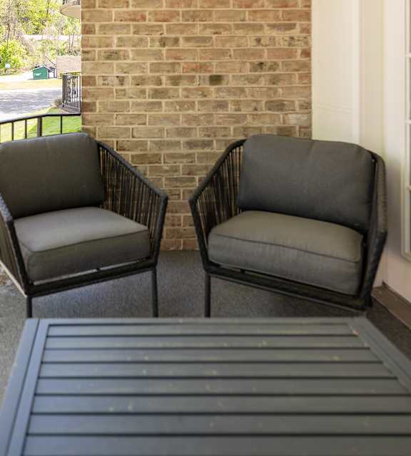 Two chairs are on a porch at The Brittany Apartments, Pikesville, MD