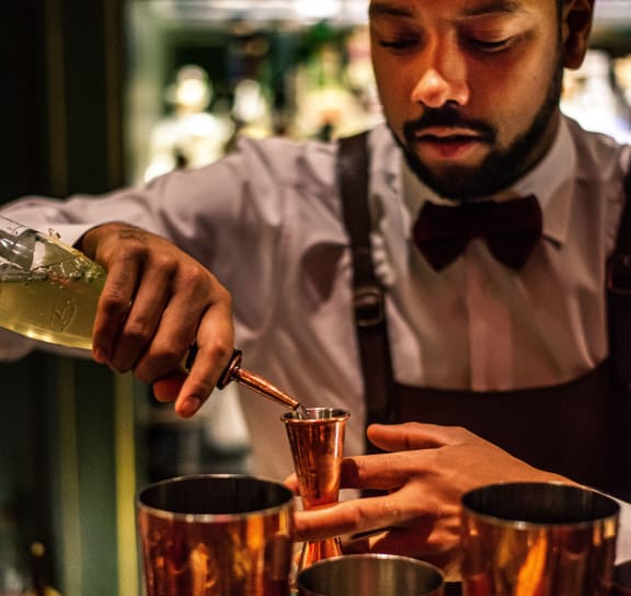 A bartender with cocktails at Highland Mill Lofts in Charlotte, NC