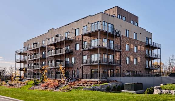 A large, modern apartment building with balconies and a mix of brick and siding exterior.