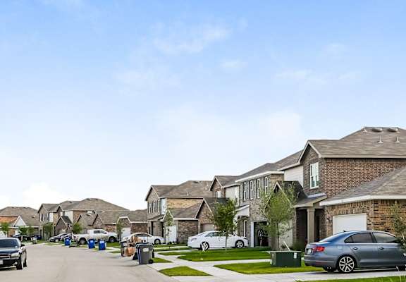a row of houses with cars parked on the street