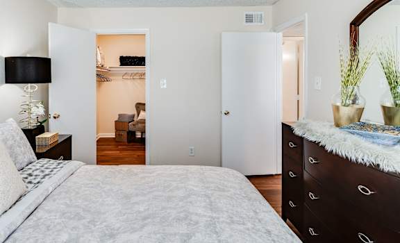 a bedroom with a large bed and a dresser with a mirror